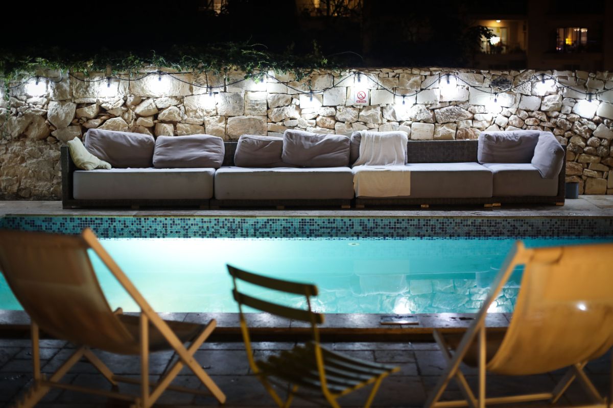 Night-time Patio pool side with stone wall