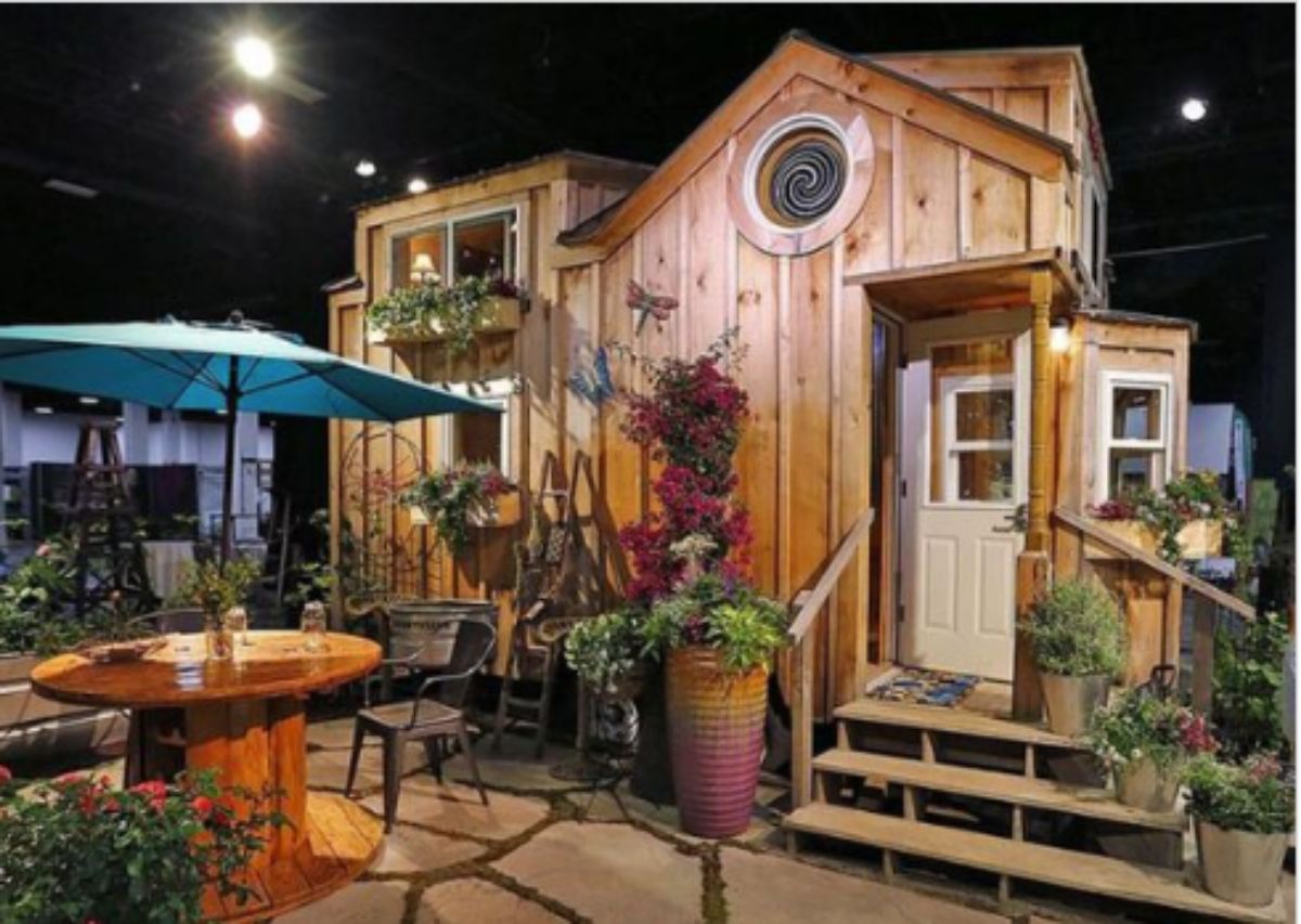 small log cabin with plants in the backyard