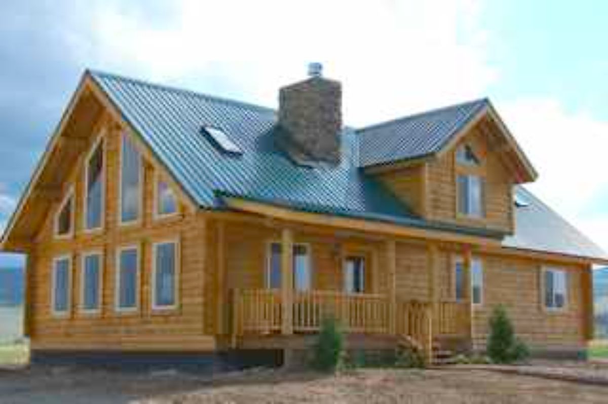 huge log home with blue roof