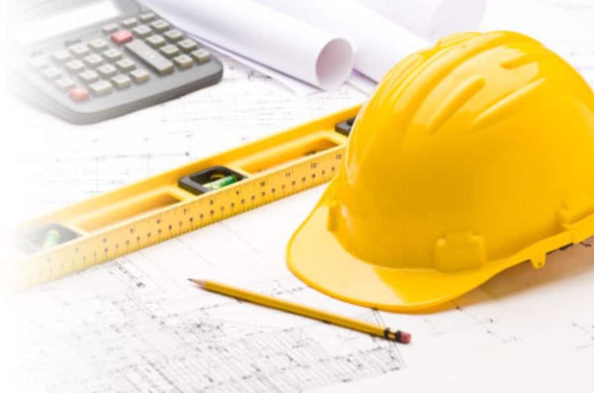 hardhat and calculator on blueprints