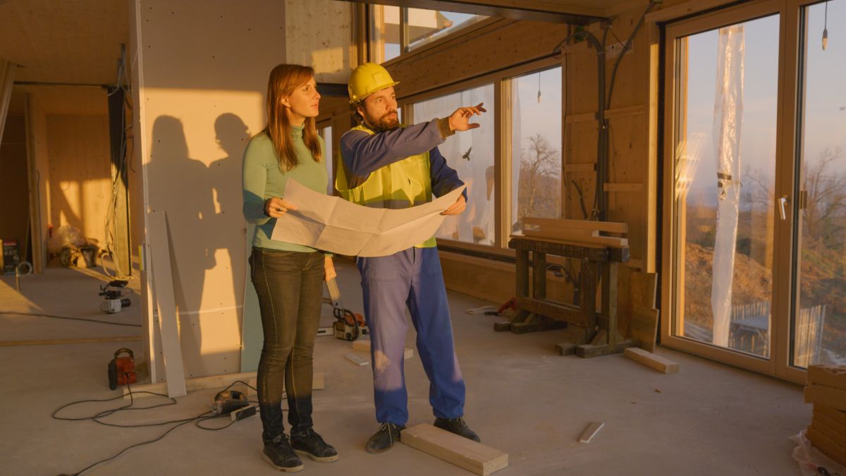 log cabin builder with owner holding a floor plan