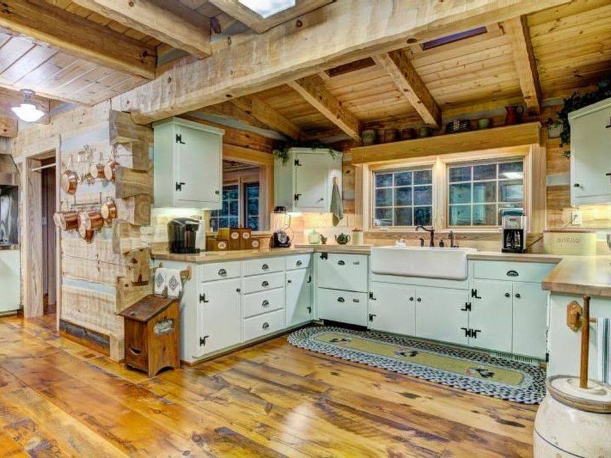 U shaped kitchen in log cabin with green cabinets