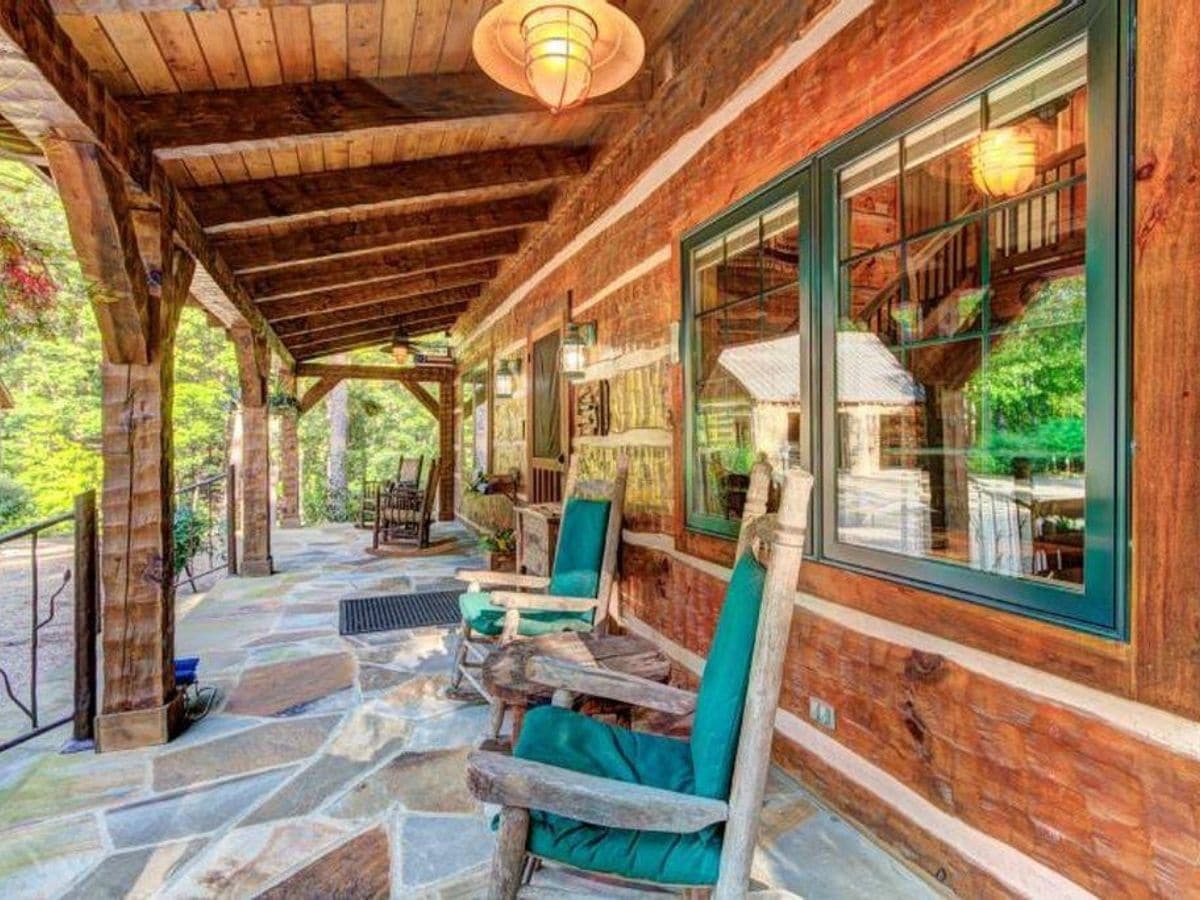 green rocking chairs on porch of log cabin in arkansas