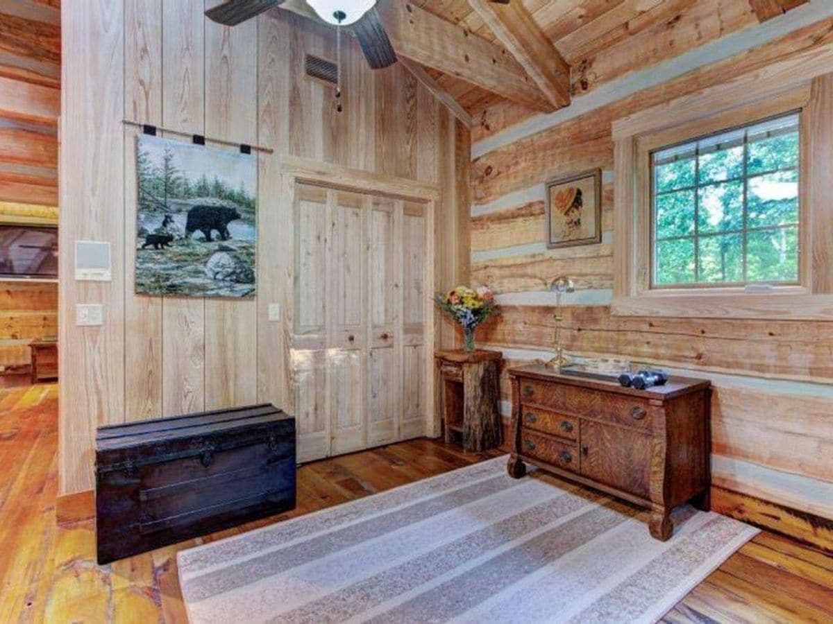 storage closet with wooden trunk next to it inside log cabin