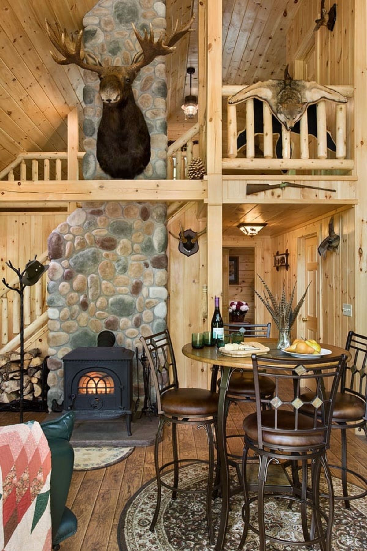 stone fireplace with deer head mounted above against loft wall