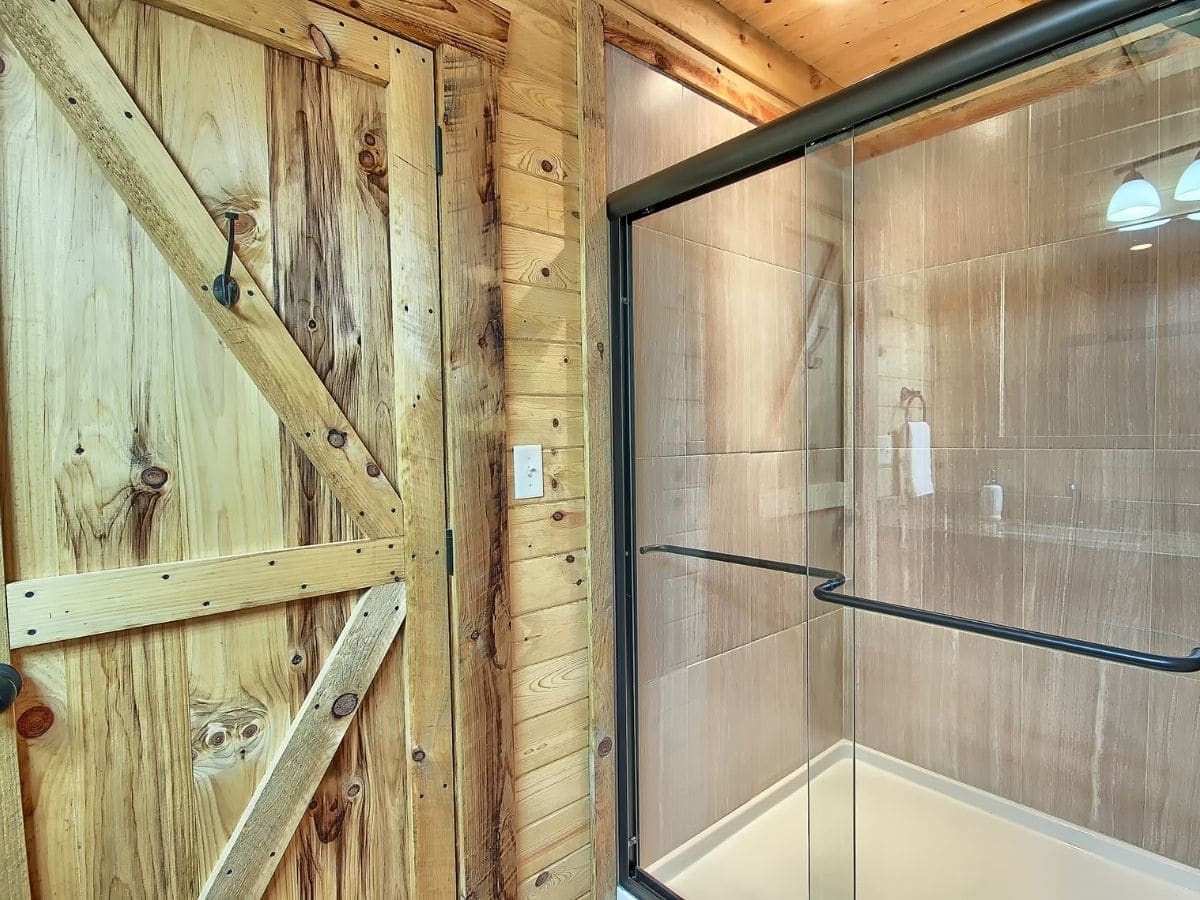 glass shower door next to barn door bathroom closure