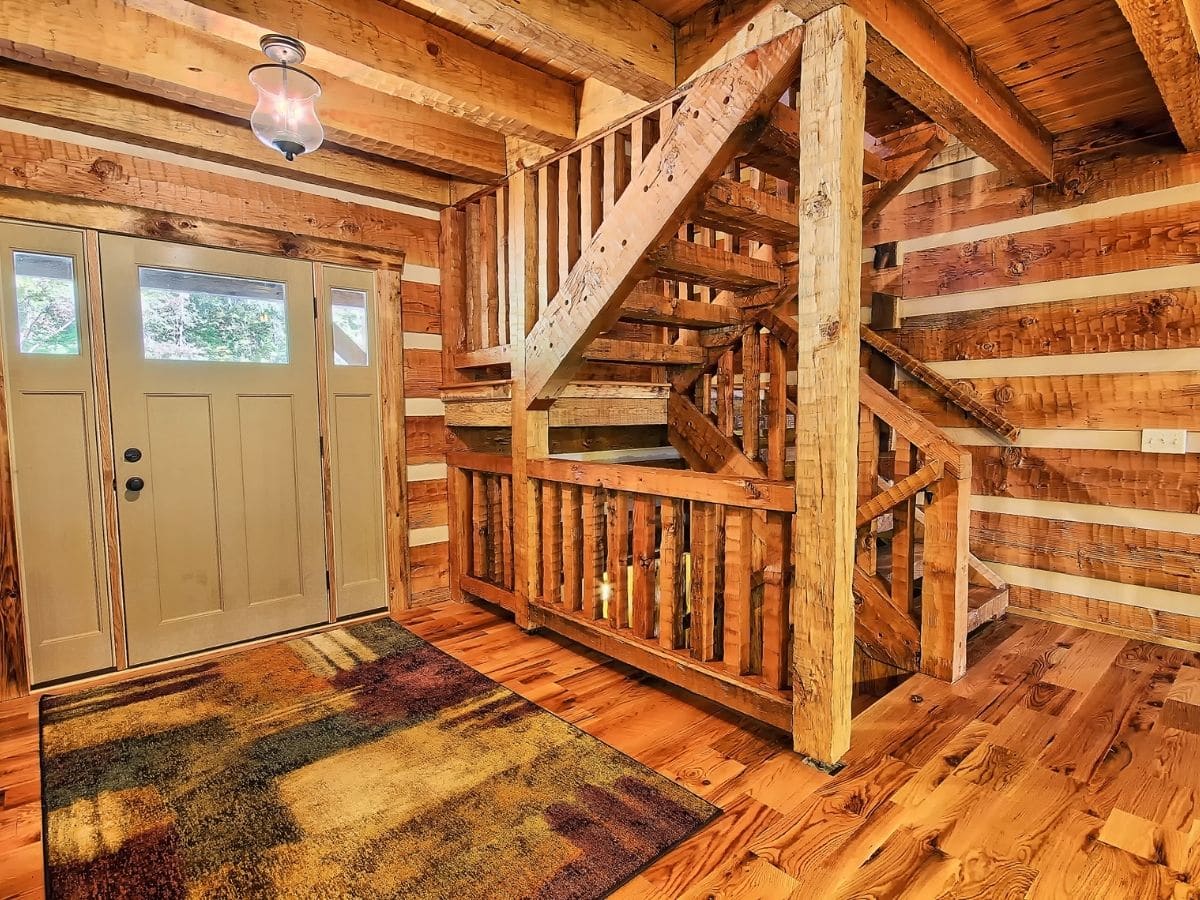 entry way to log cabin with rug in front of door