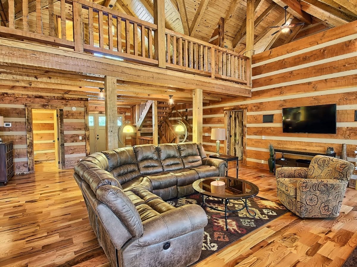 brown sofa on rug in log cabin living room