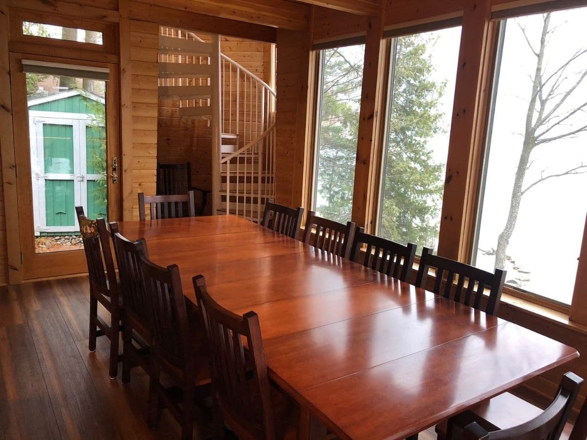 8 person dining table in four seasons room with lake view in background
