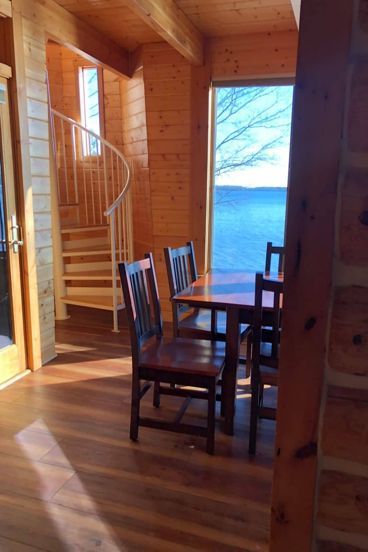 spiral staircase in background of dining area with window next to it