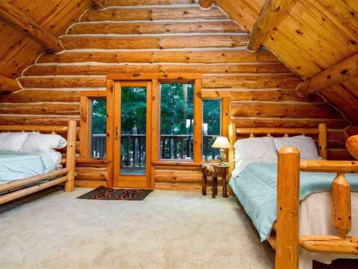 loft in log cabin with bed on both sides of windows