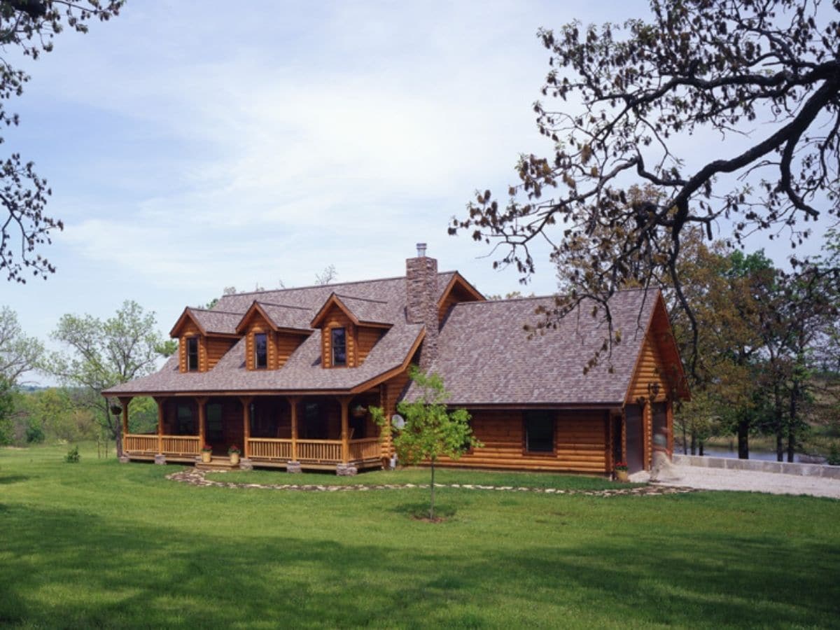 log cabin with attached garage in green field