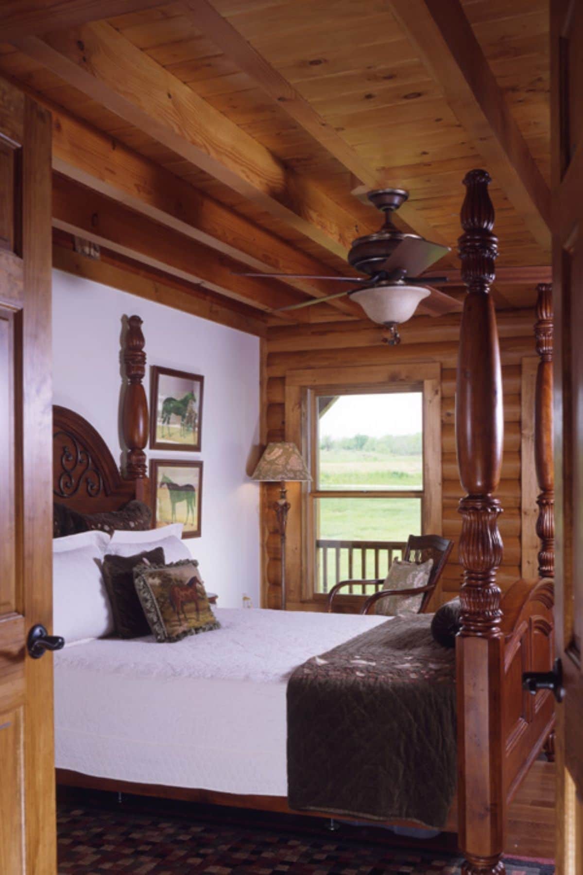 dark wood bed frame against white wall in log cabin