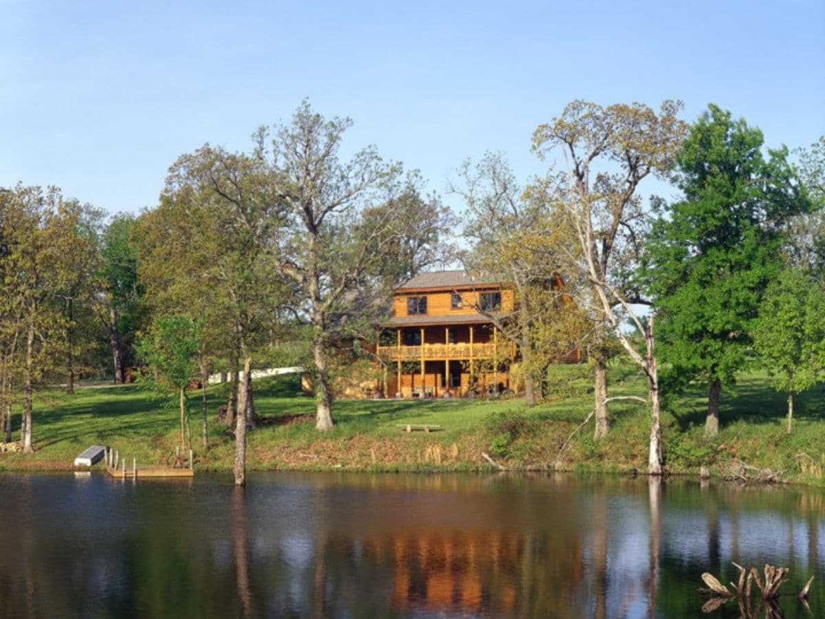 cabin in trees behind pond