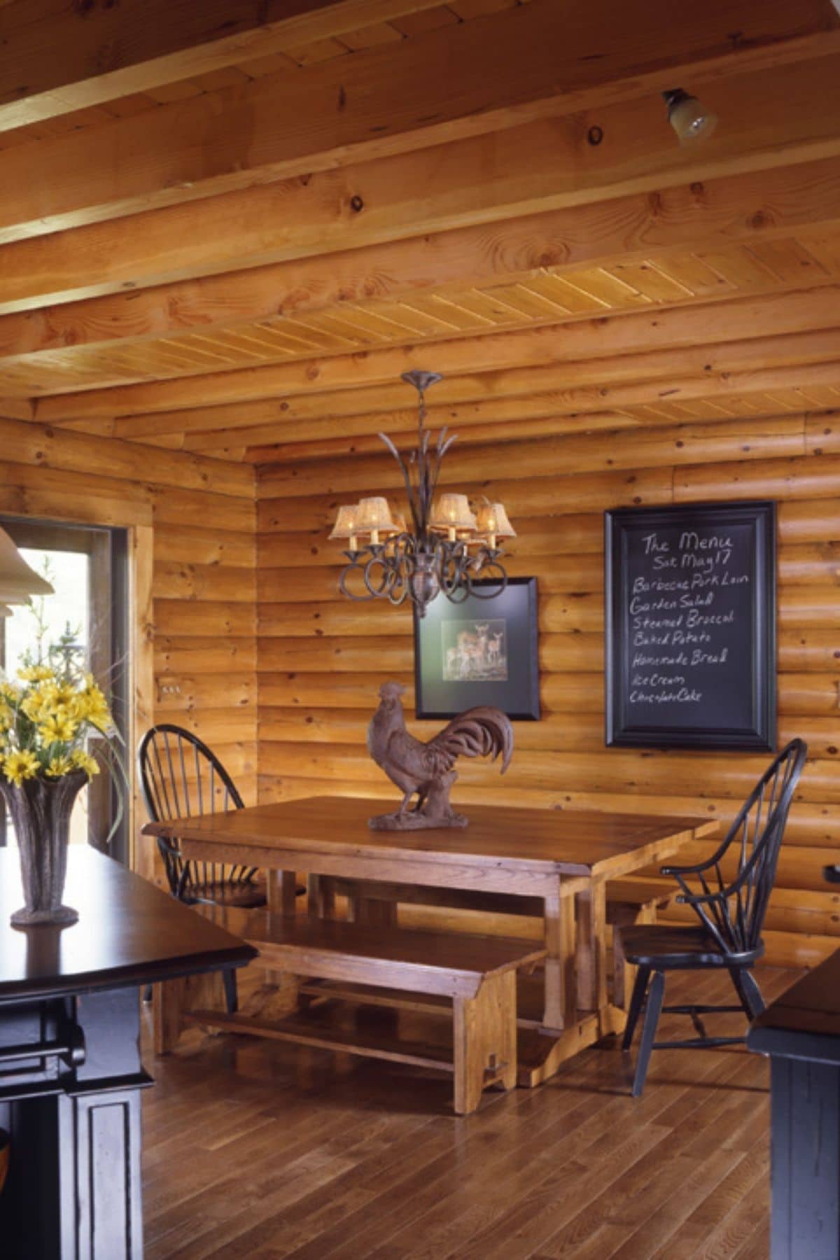 dining table with rooster ornament in center of log cabin dining room