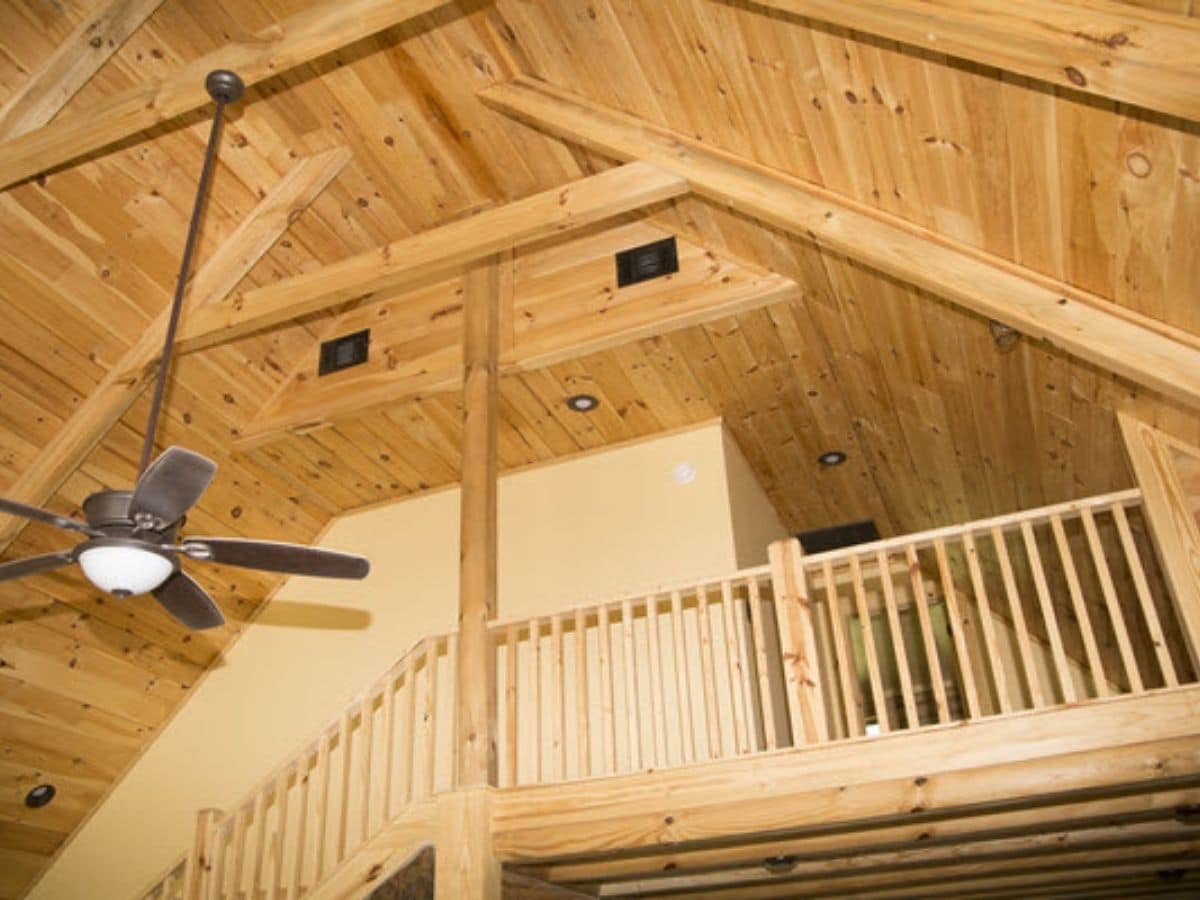 open loft in log cabin with ceiling fan hanging down