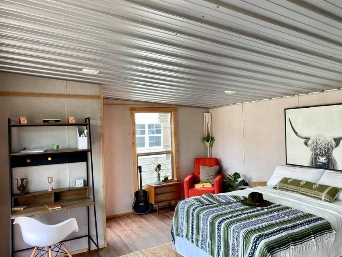 corrugated metal ceiling in tiny home with bed on right