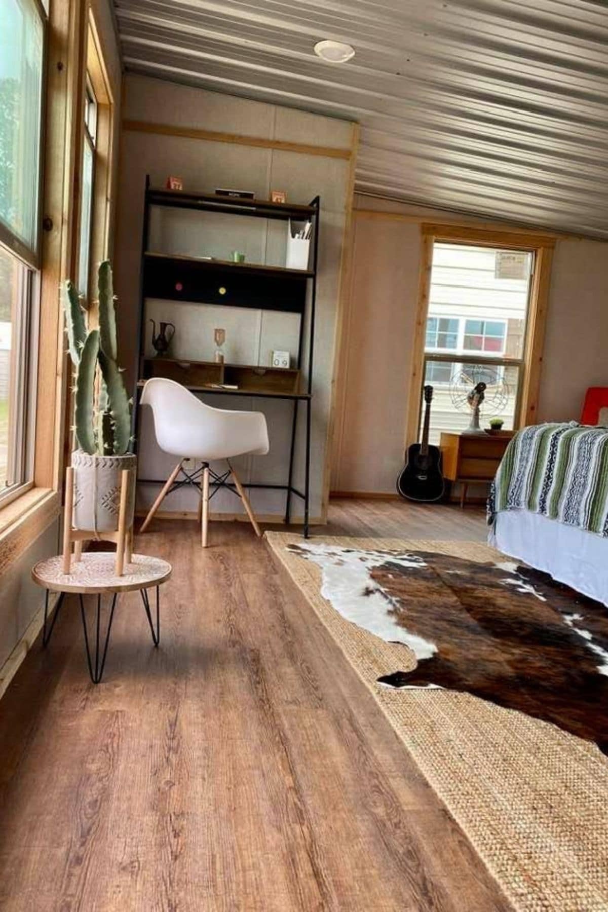 bed on right and desk on left with animal print rug on floor