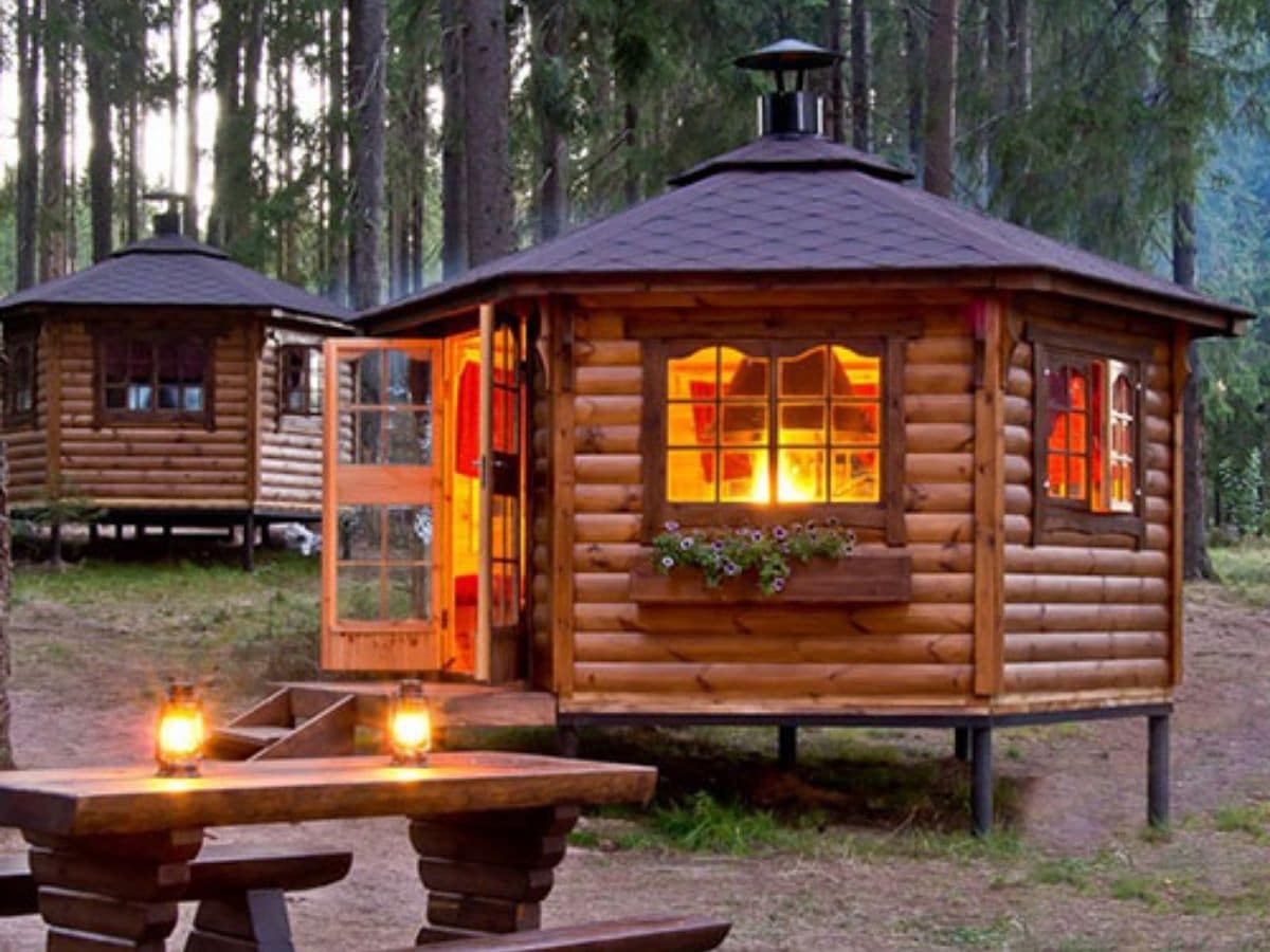 log cabin with door open and fire inside on stove