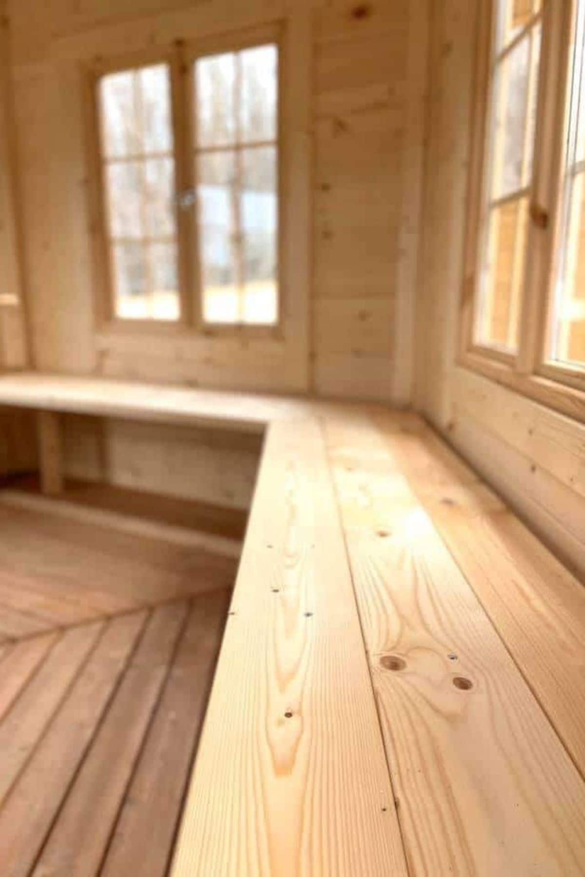 wooden bench beneath windows