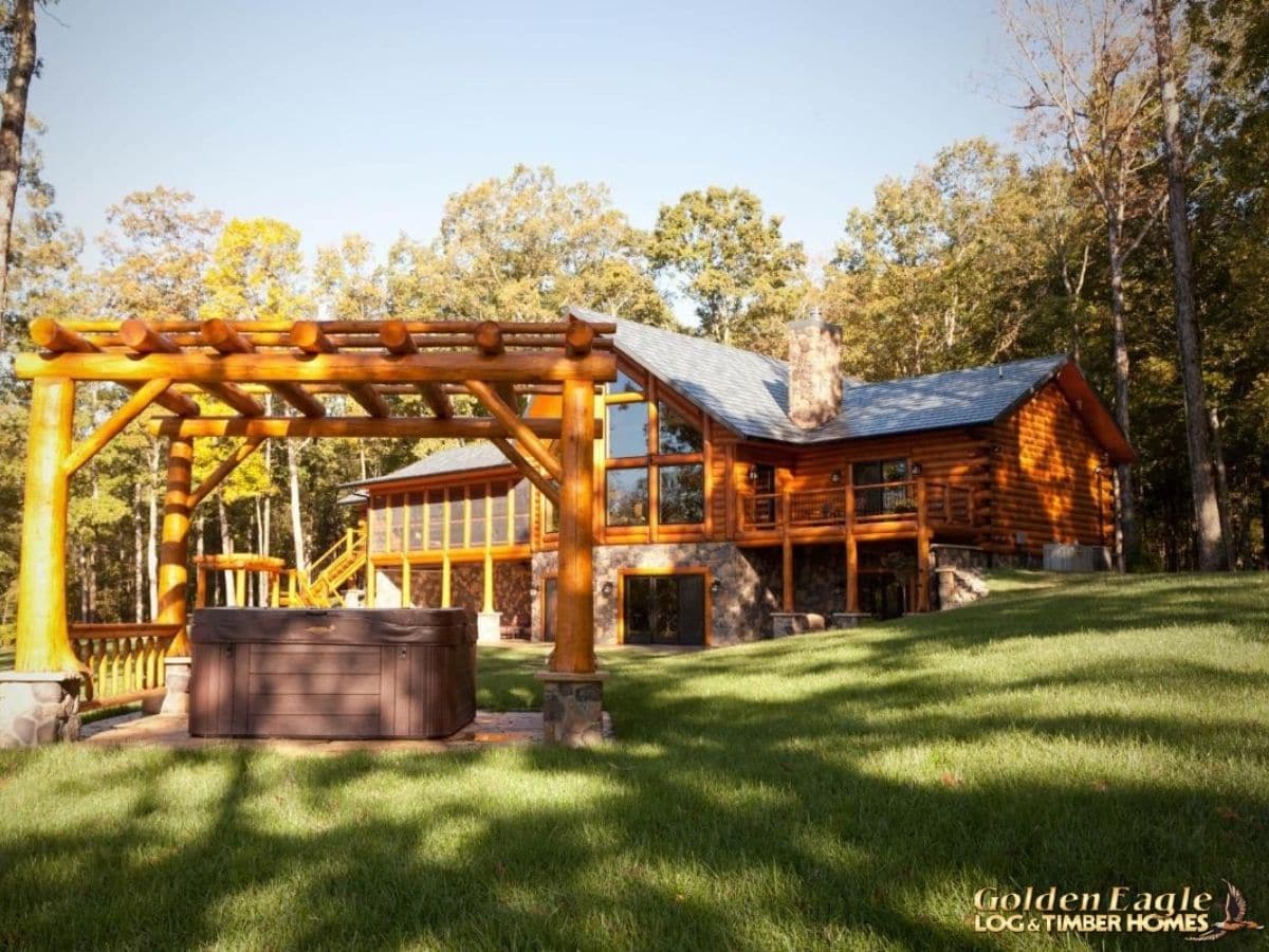 hot tub in gazebo behind log cabin