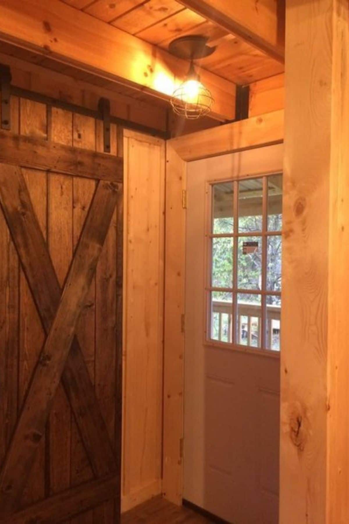 entry to log cabin with barn wood door next to front door