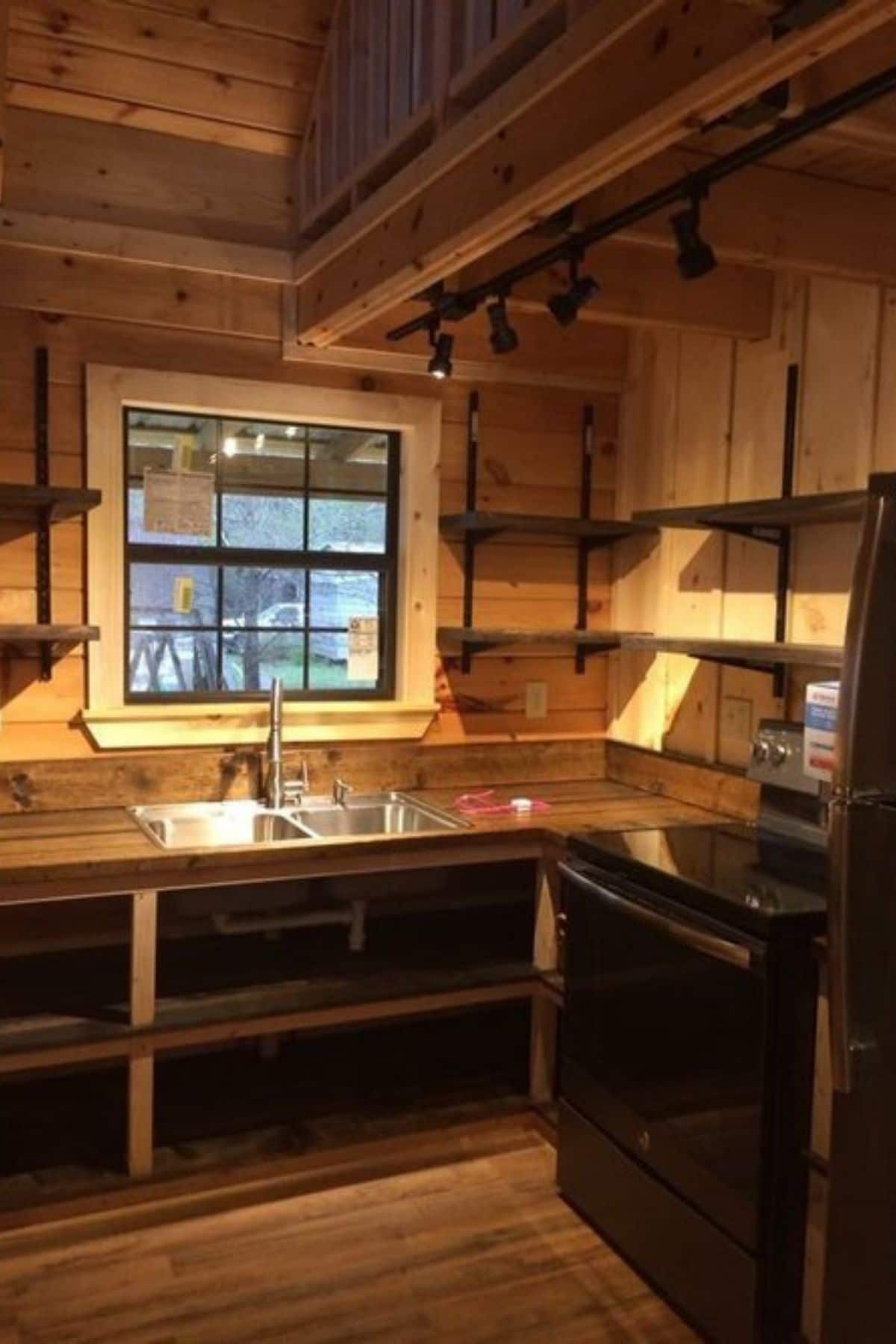 modern kitchen with open shelves in cabin with dark wood counters