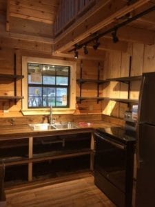 kitchen in log cabin with black appliances