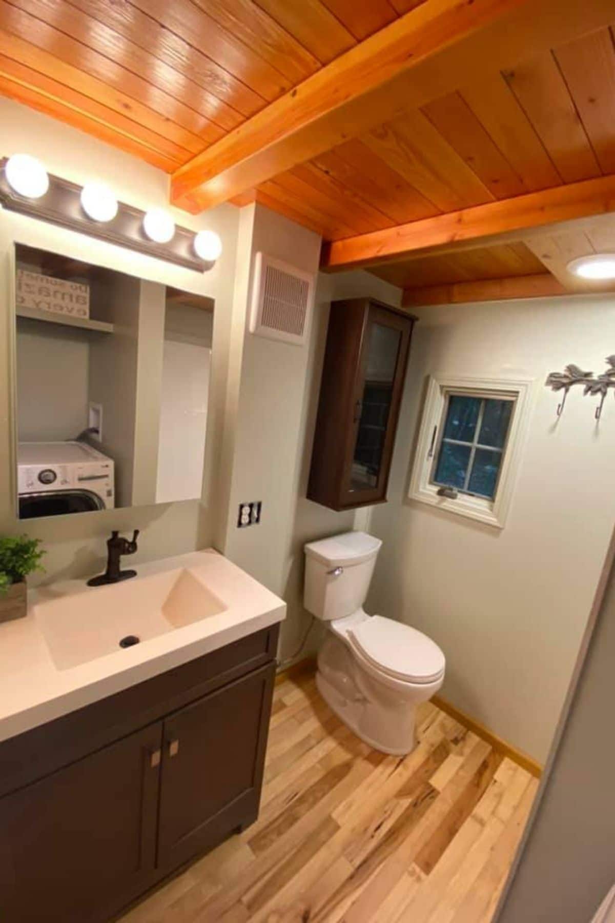 bathroom with toilet on far wall and vanity with lights in left corner
