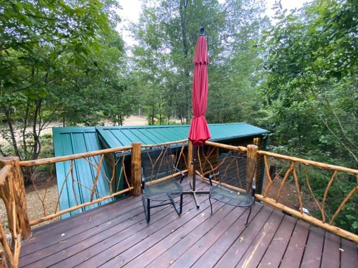 view onto roof of cabin from deck with wood railing