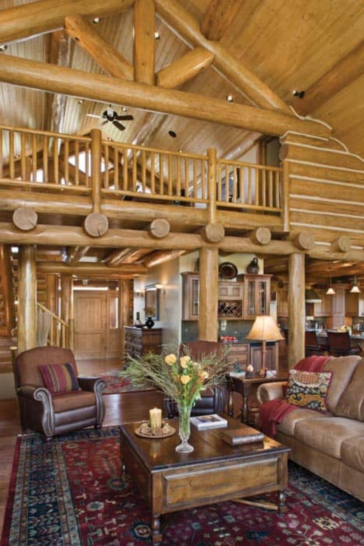 living room with brown sofa underneath open loft with wood railing