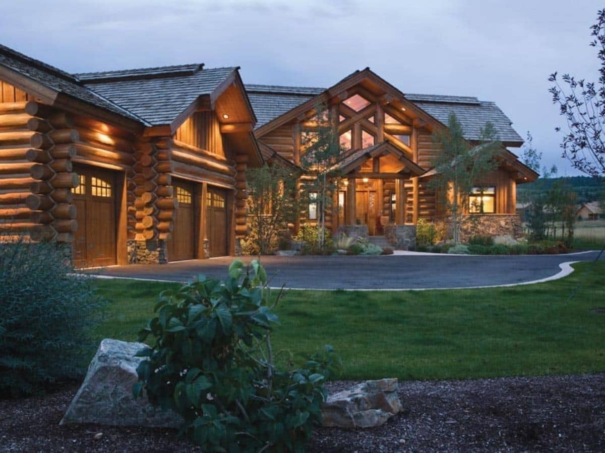 log cabin with attached garage on left of image