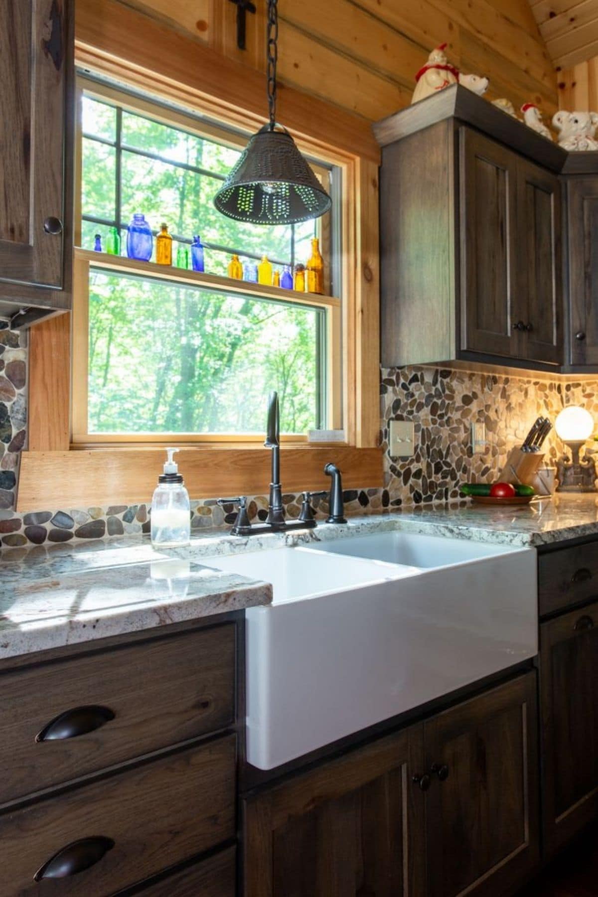 white farmhouse sink in dark wood cabinets