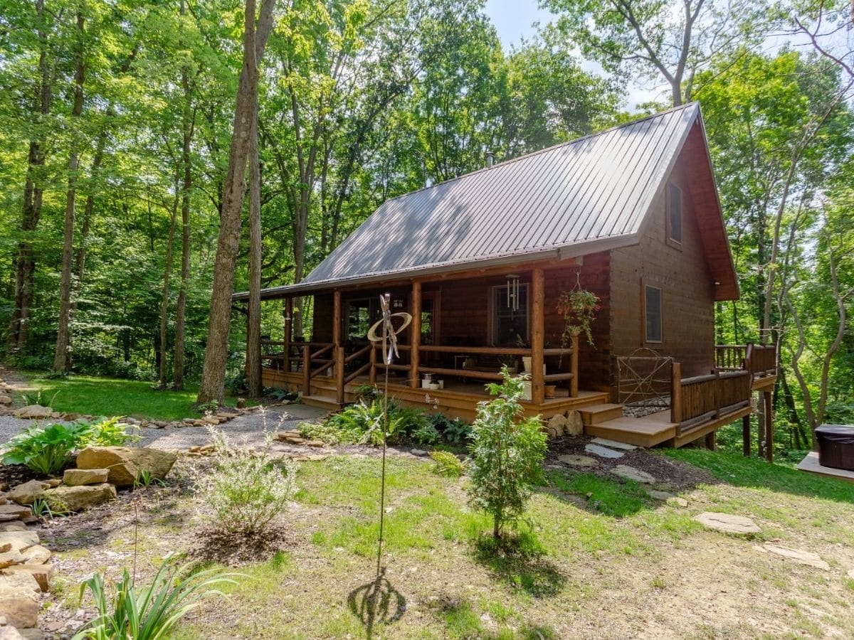 log cabin with light wood and porch set into woods