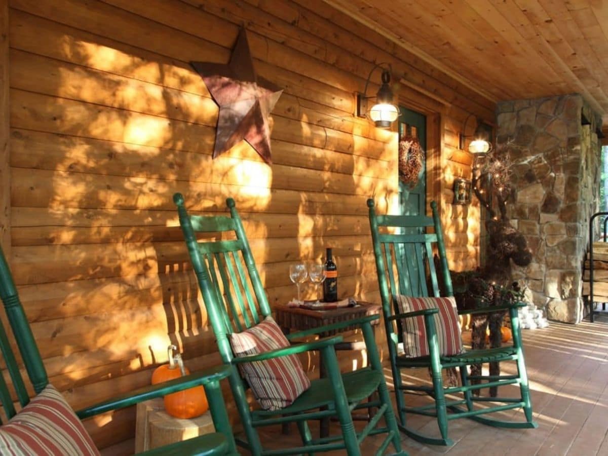 wood log porch with green rocking chairs