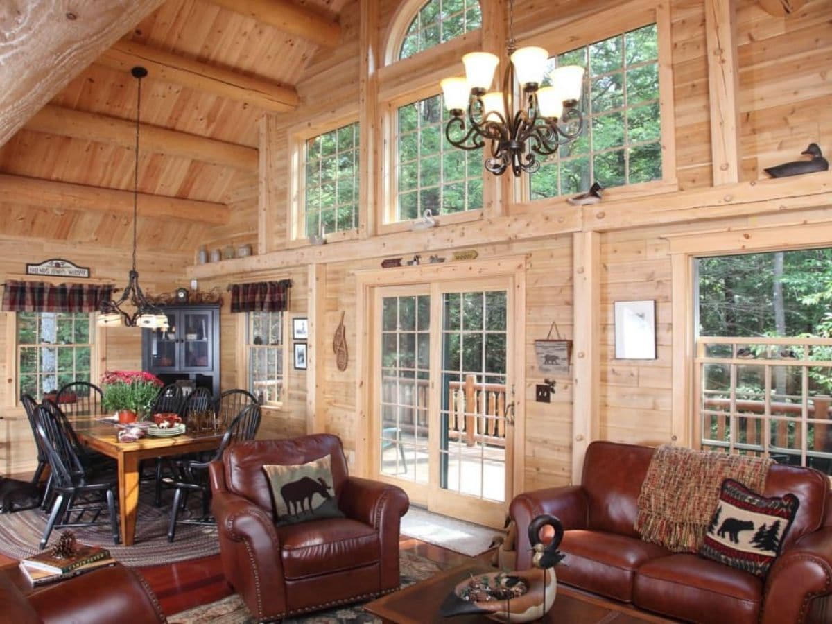 great room with picture windows and french doors with brown leather sofas