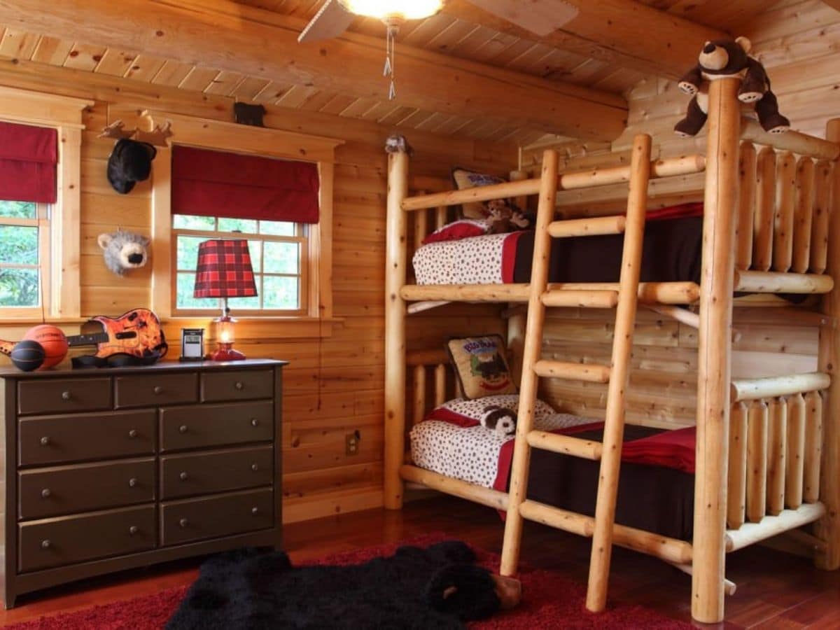 bedroom with log walls read carpet and log bunk beds
