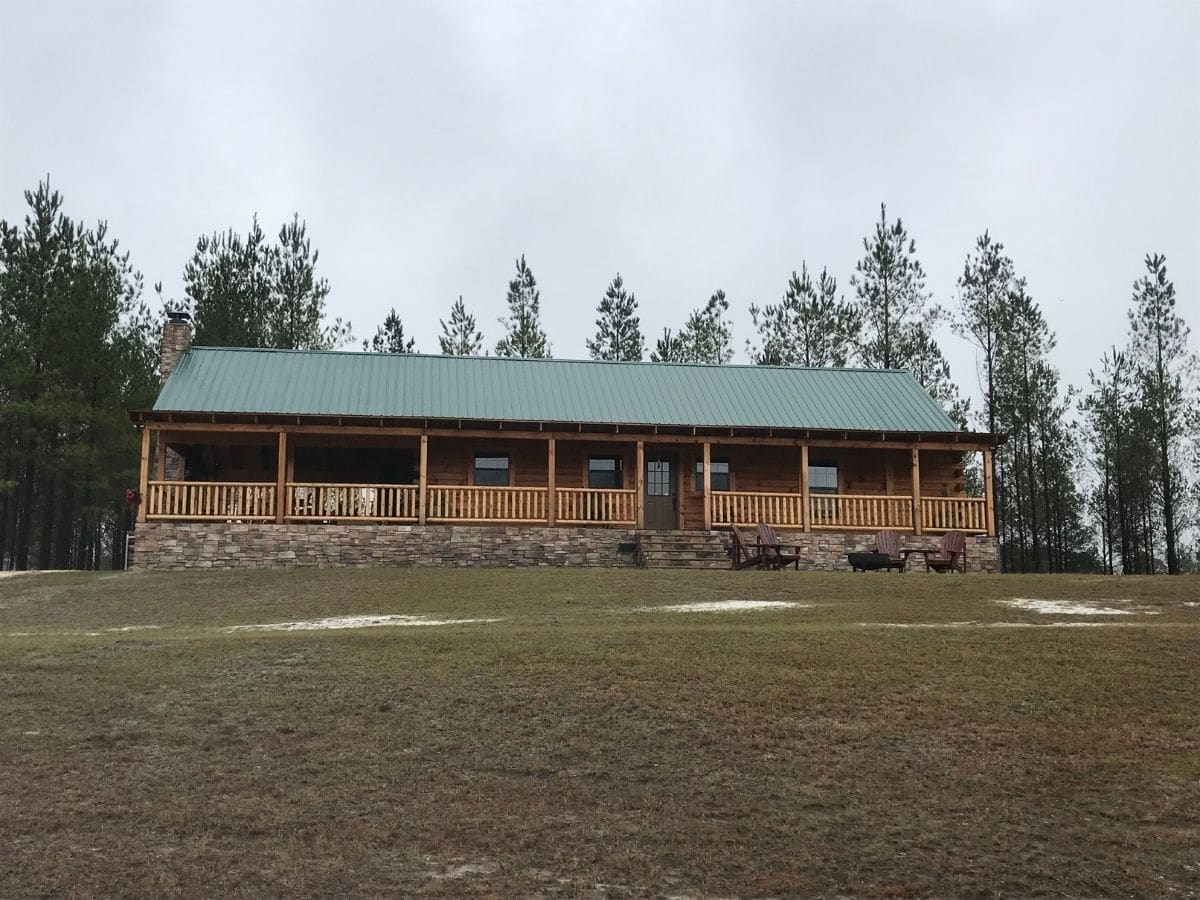 front of log cabin with green roof