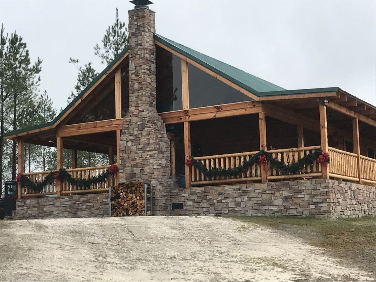 end of log cabin with porch and garland hanging on side