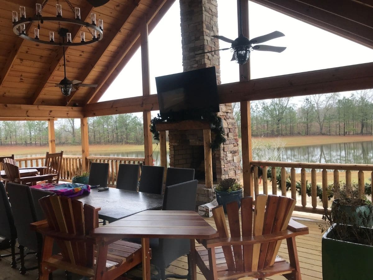 table and chairs under porch awning with stove on end