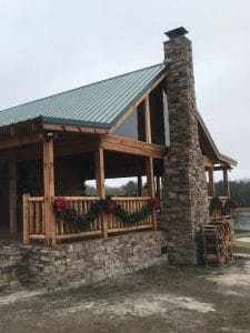 end of log cabin with stone chimney
