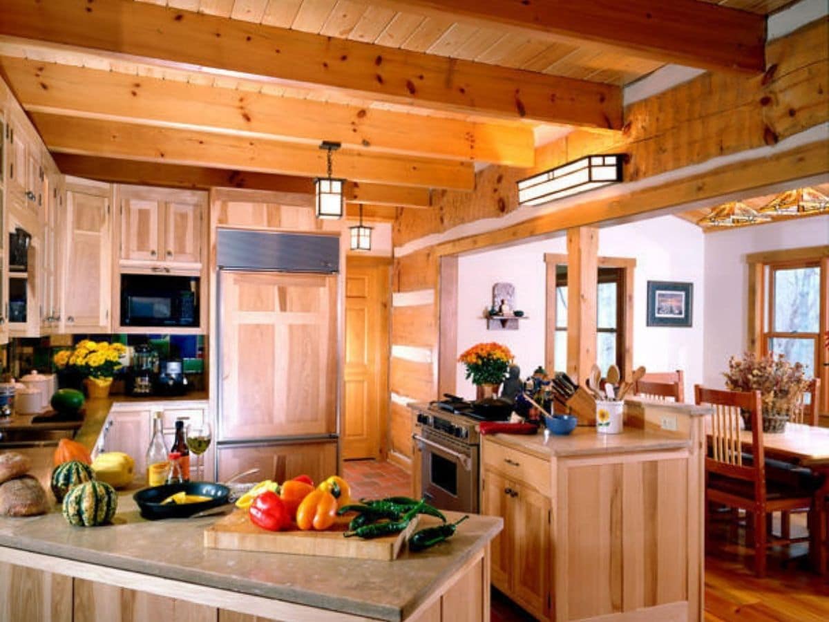 view into modern kitchen with wood cabinets in log cabin