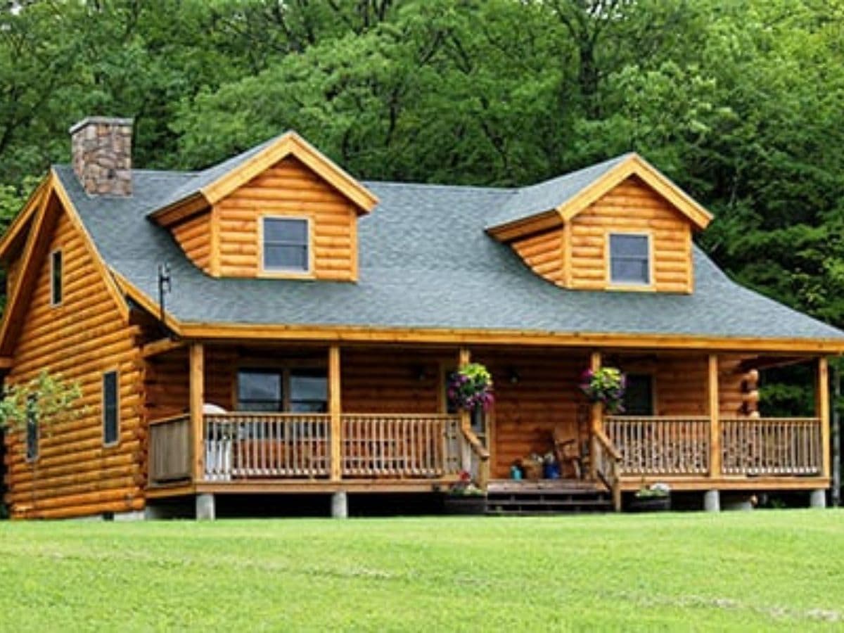 Log cabin with front porch and two dormer windows on front