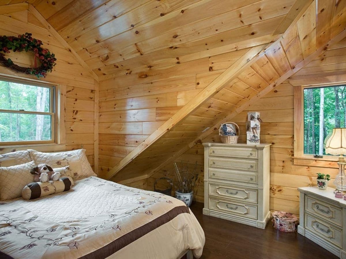 log cabin second floor bedroom with cream dresser against wall