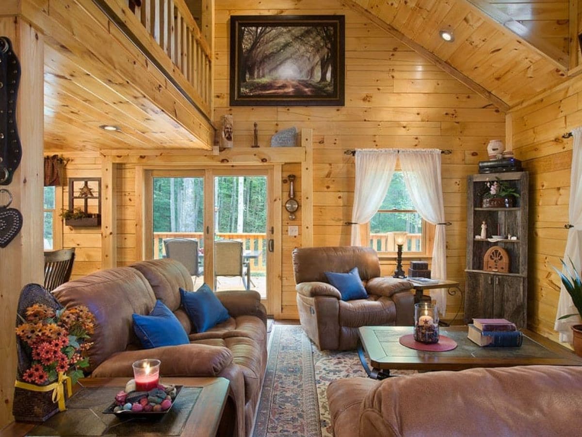 brown sofas with blue pillows in log cabin living room