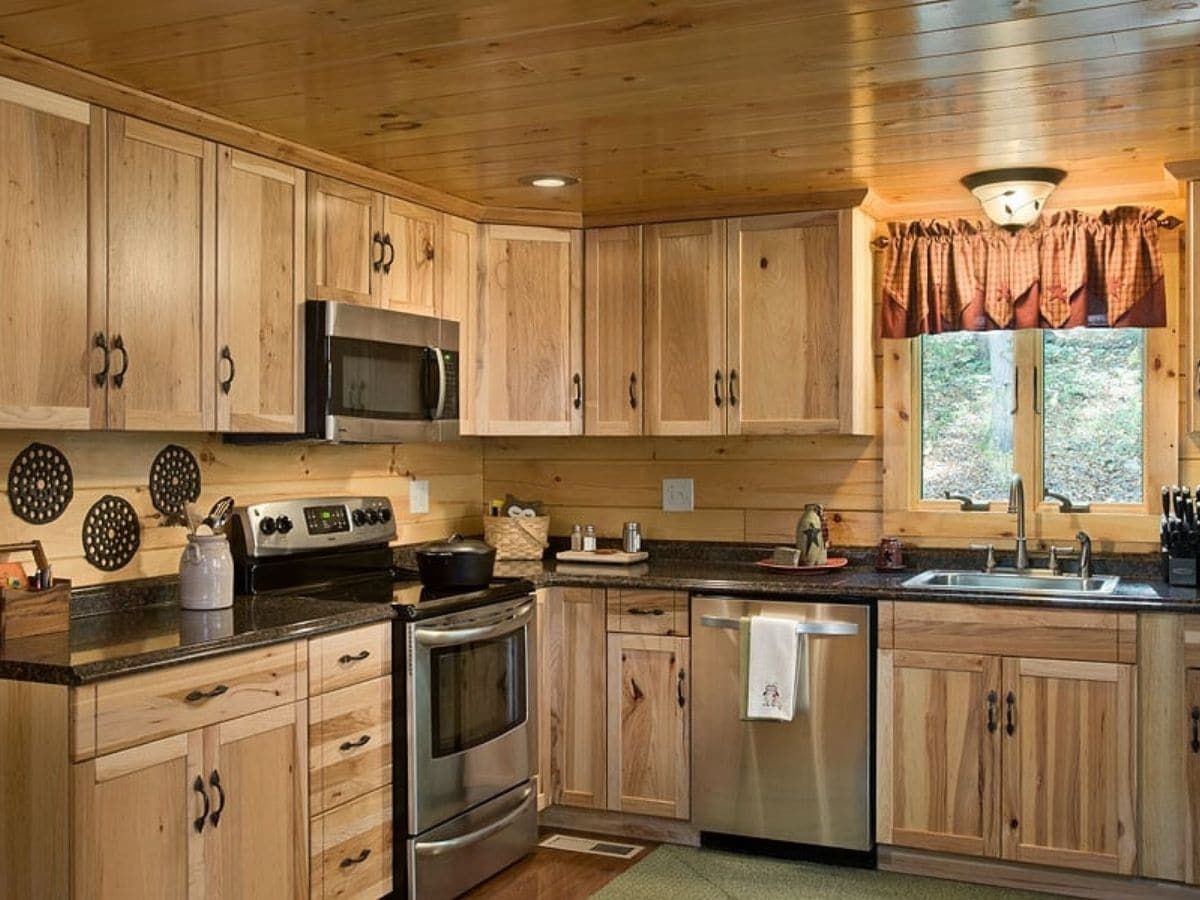 stainless steel stove and dishwasher in light wood cabinets of kitchen