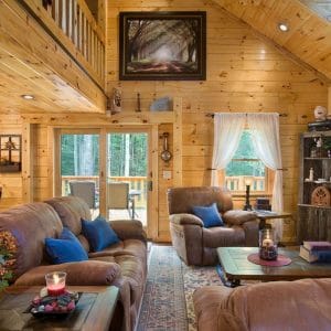 brown sofas with blue pillows in log cabin living room