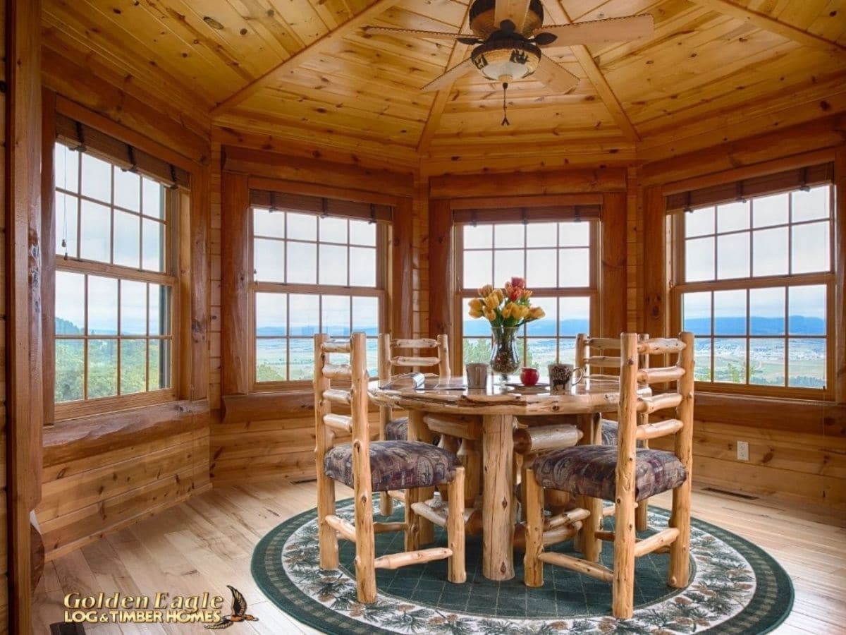 round log table in middle of round room with windows on all sides