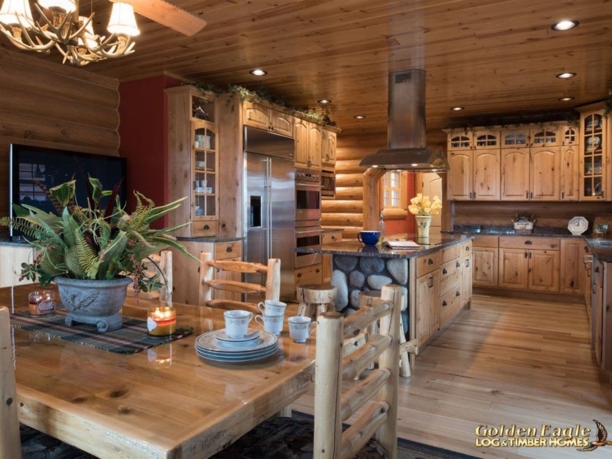 island in kitchen behind dining table with wood cabinets and stainless steel appliances