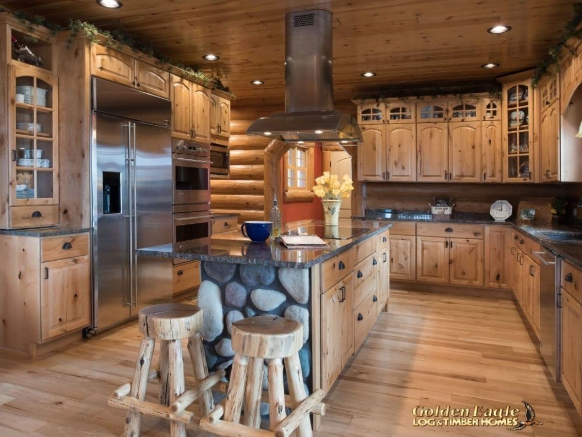 stools by island in middle of modern kitchen with wood cabinets